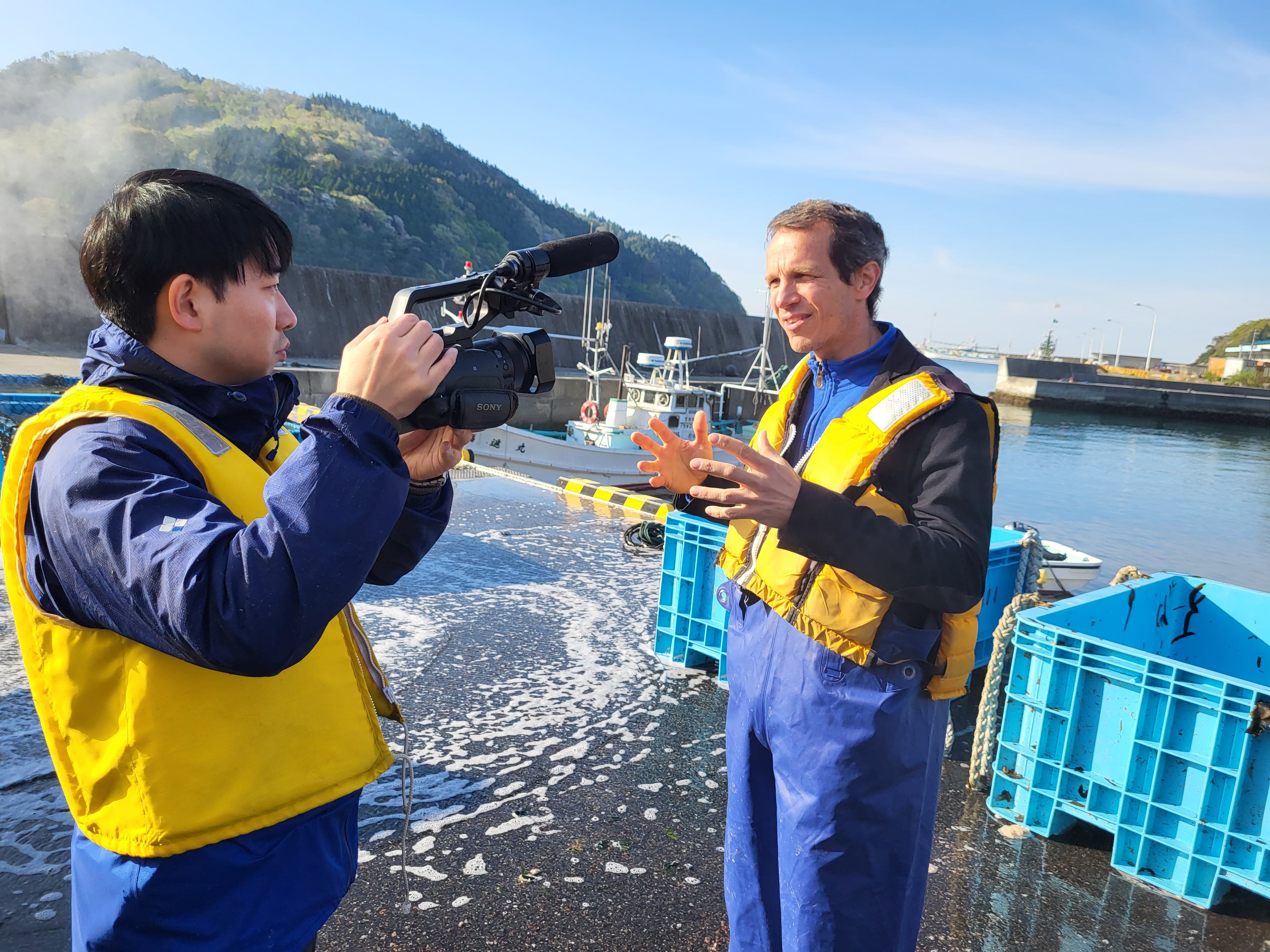 Man being recorded in front of shipping dock